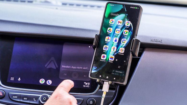 A smartphone using Google Maps navigation while hosted into a car mount