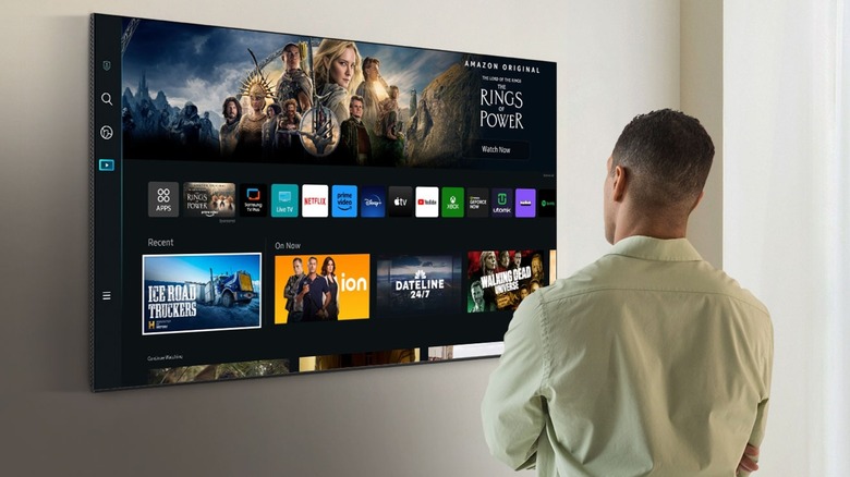 Man looking at Samsung tv mounted to wall showing Amazon Prime shows