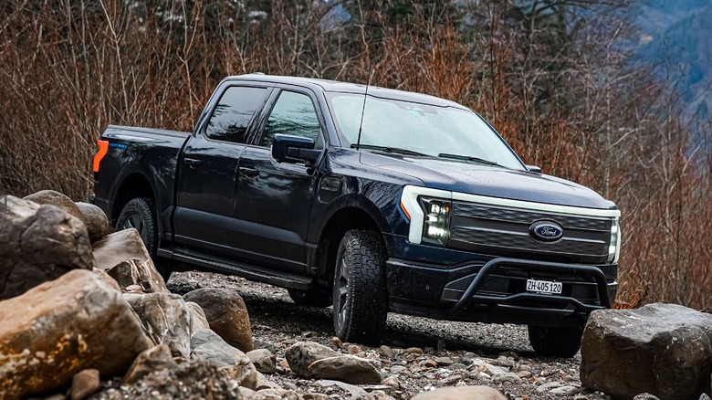 Ford F-150 Lightning driving over tough terrain.