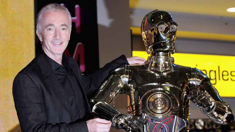 Actor Anthony Daniels poses with a C-3PO replica