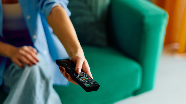 A person pointing a TV remote.