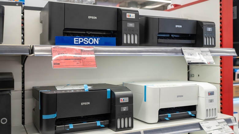 Several Epson printer models on display at an electronics store