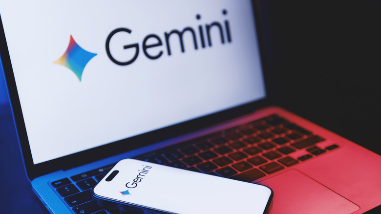 The Google Gemini logo on a laptop, with a smartphone sitting on the keyboard