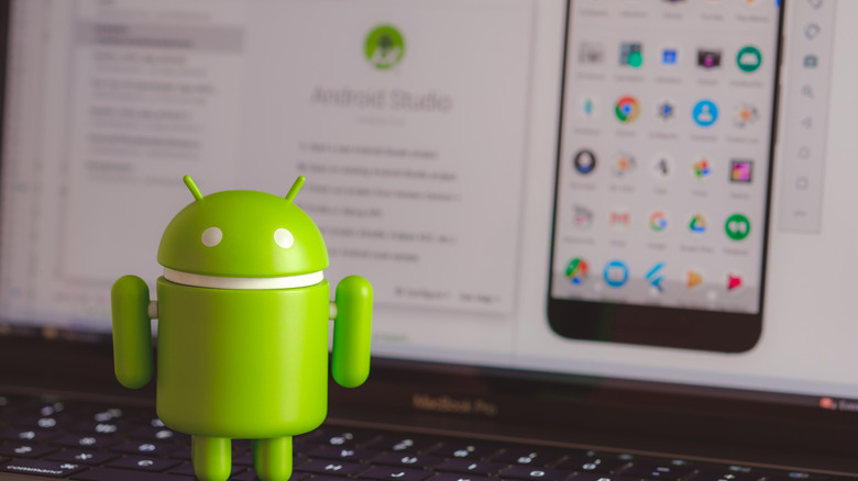 Android mascot figure on laptop keyboard