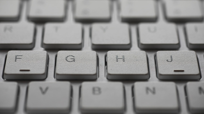 A close up of a keyboard showing bumps on the 'F' and 'J' keys