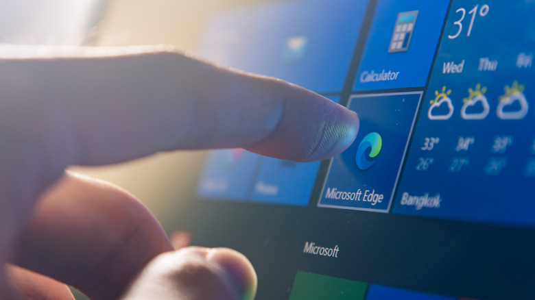 User tapping on the Microsoft Edge application icon.