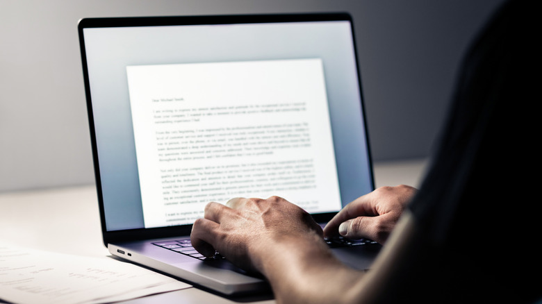 Person typing and using a word processor on laptop