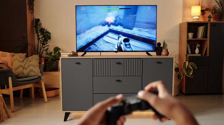 a gamer playing on a console in their living room