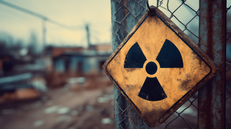 nuclear danger sign on fence, blurred background