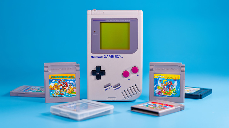 An assortment of game cartridges surrounding a Game Boy