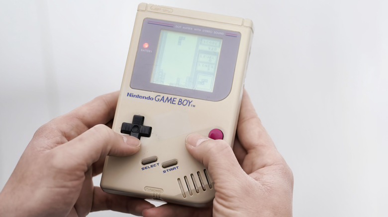 A person playing Tetris on a Game Boy