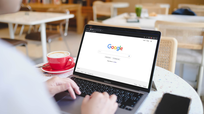 A person using Google Search in a coffee shop.