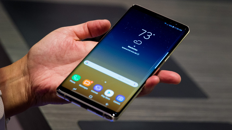 Hand holding a Samsung phone with a curved display