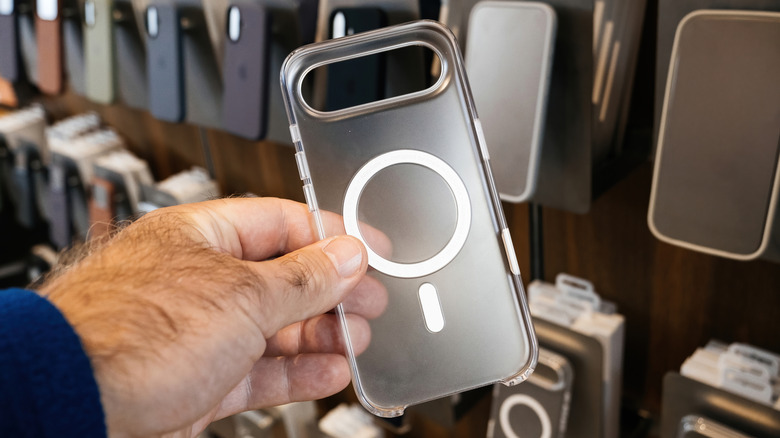 A man's hand holding a transparent MagSafe iPhone case.