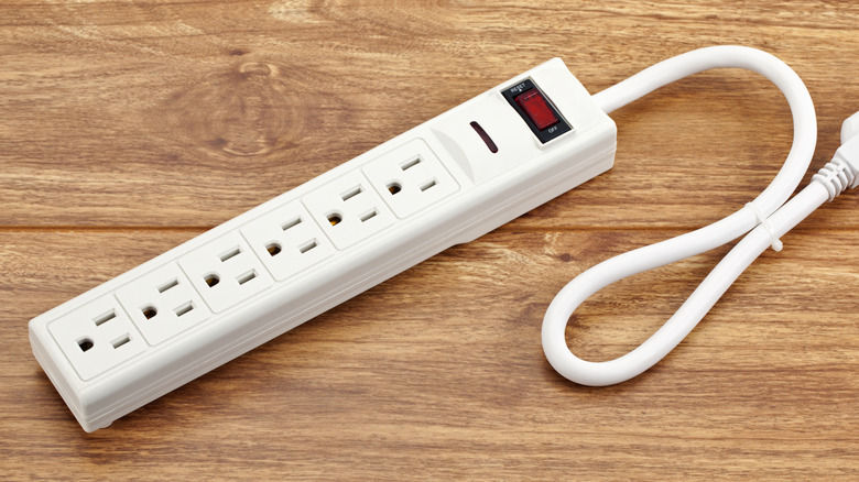 Close up of a power strip with outlets and buttons visible.