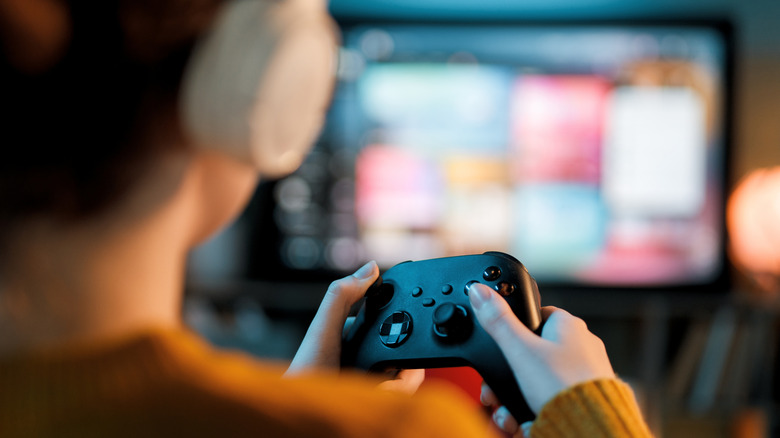 A person playing video games and wearing headphones