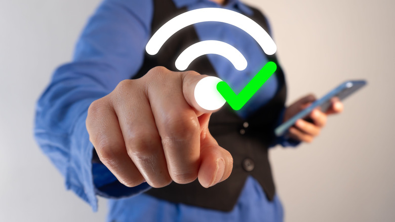 A finger pushing a Wi-Fi symbol with a green checkmark next to it