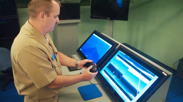 Naval officer using Xbox 360 controller in test setup for Virginia-class submarine