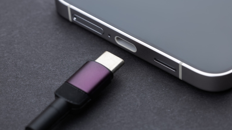 USB-C cable resting near the proper USB port on the bottom of a smartphone.