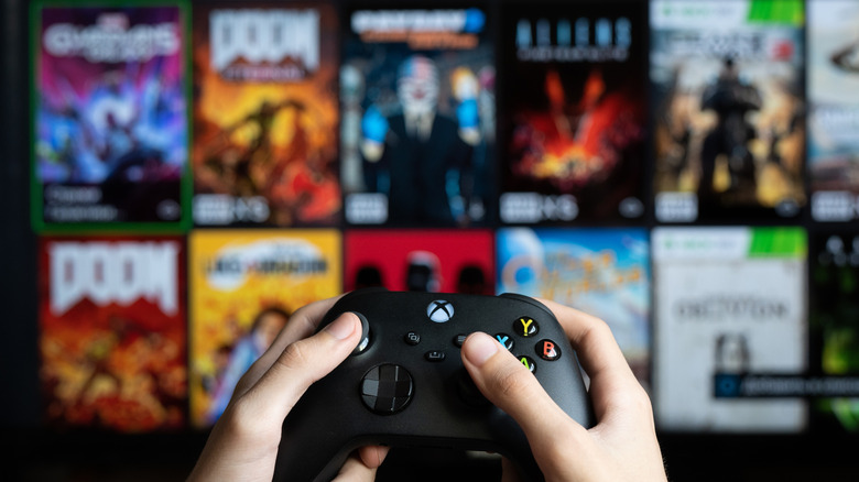 A wall of Xbox games behind a controller.