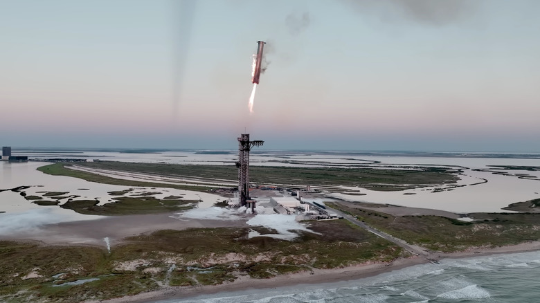 A Super Heavy booster returning to the SpaceX launch tower at the end of the Starship's fifth test flight in October 2024.