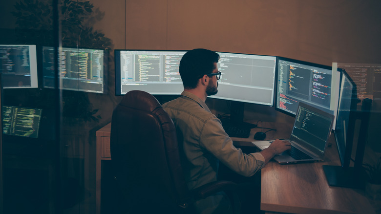 A man working on several multiple Linux computers at once