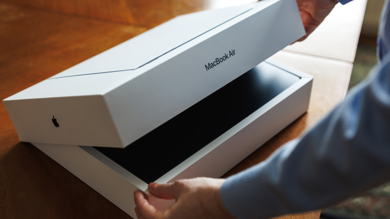 A person opening the box of a brand-new MacBook Air laptop