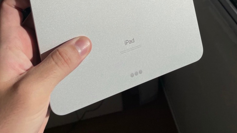 A hand holding an iPad