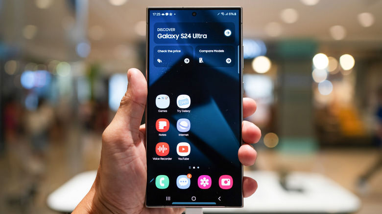 A closeup of someone holding a Galaxy S24 Ultra inside a Samsung store
