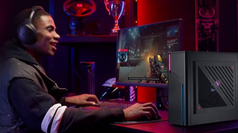 Person playing FPS game on Asus ROG G22CH desktop gaming computer