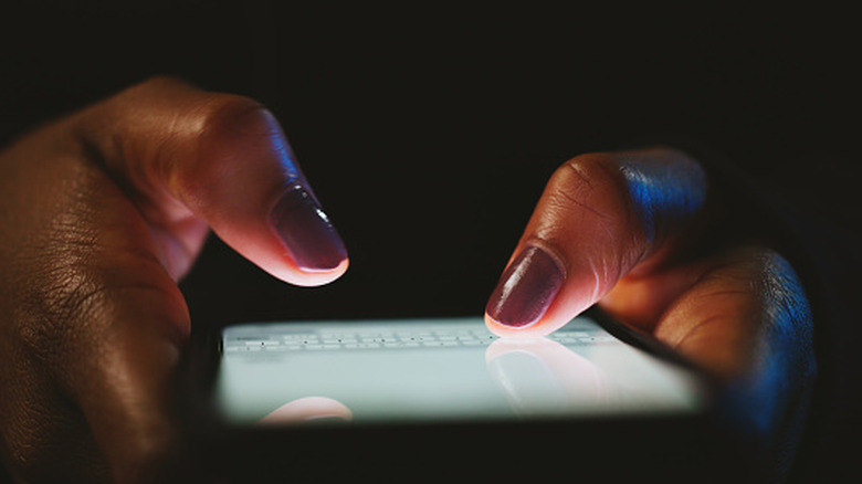 Close up of hands typing on a smartphone