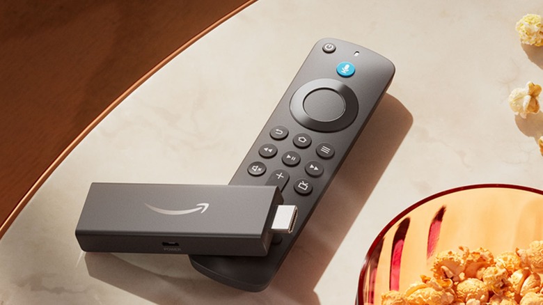 Amazon Fire TV Stick and remote on table next to bowl of popcorn
