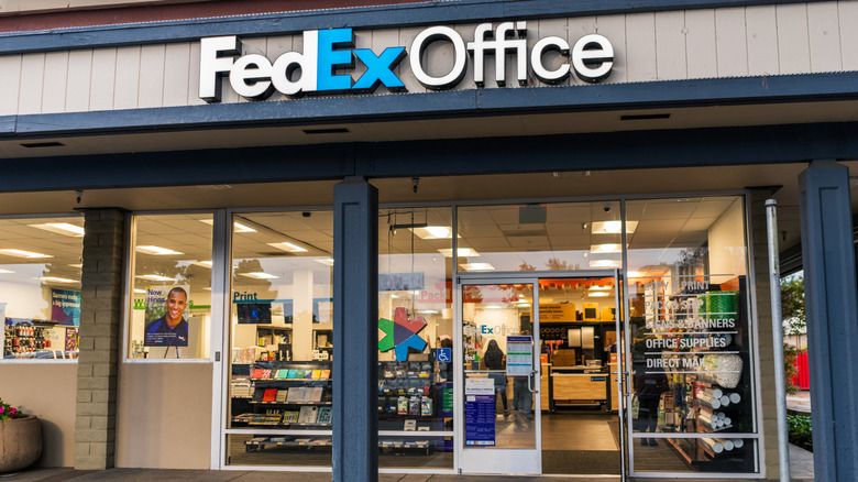 A FedEx store with a window sign that says it offers printing services