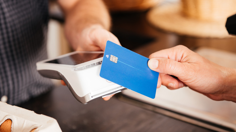 a person paying at a store with a credit card