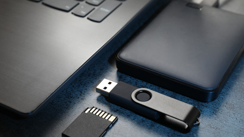 ssd, flash drive, and SD card placed next to a laptop