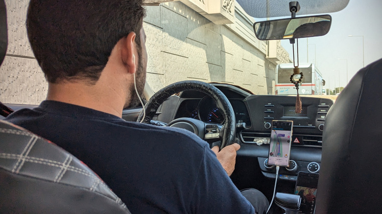 An Uber driver photographed from the back seat