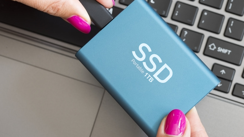 A 1TB portable SSD being connecetd to a laptop