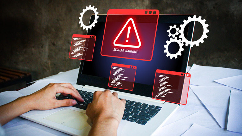 an illustration of a person using laptop with system warning label floating above it, other hovering icons and warning messages visible