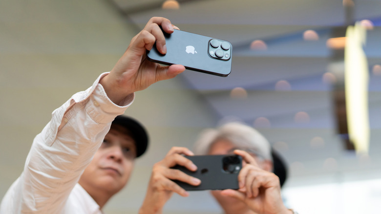 A man holds up a Japanese iPhone 16 Pro.