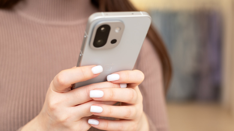a person holding a OnePlus 13T in their hands