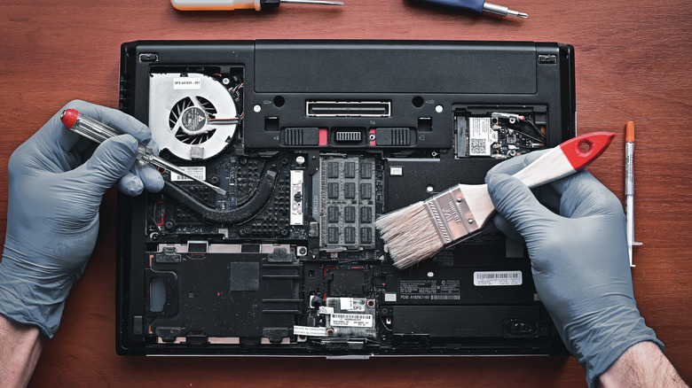 Person cleaning laptop components