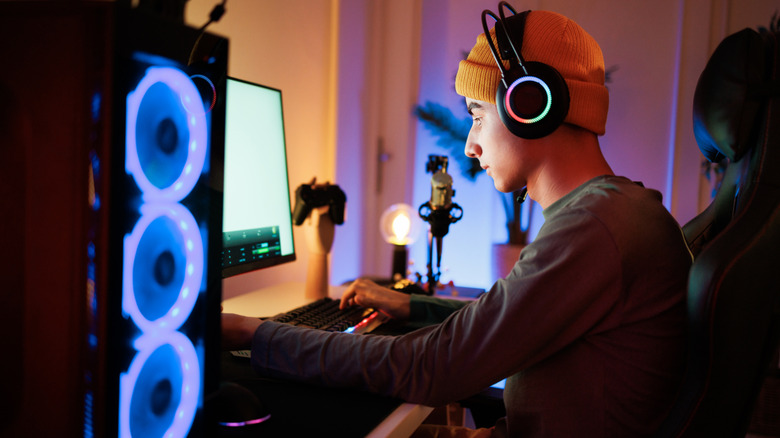 Person using a gaming PC while wearing headphones
