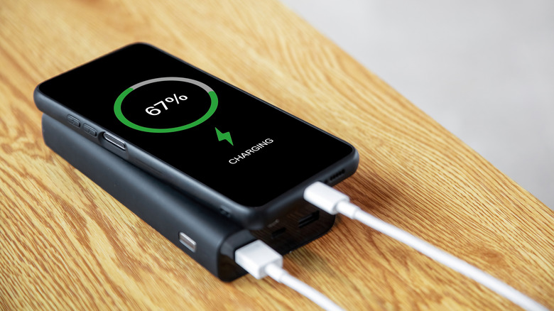 A smartphone plugged into a power bank.