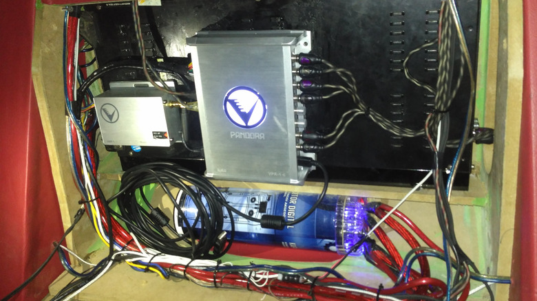 An upgraded car audio system with a dedicated amplifier and all kinds of wiring.