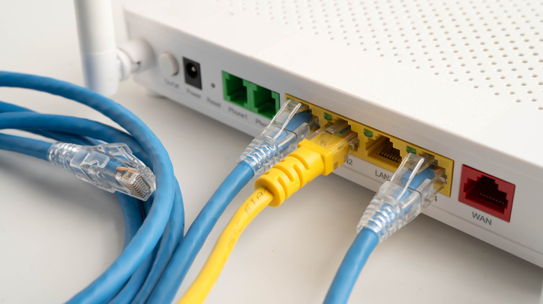 Back of a wireless router with Ethernet cables plugged in.