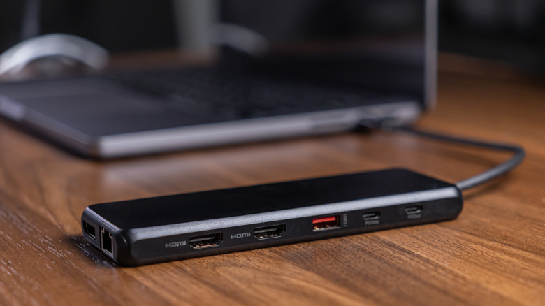 USB-C dock with HDMI, Ethernet, and USB ports beside a laptop.