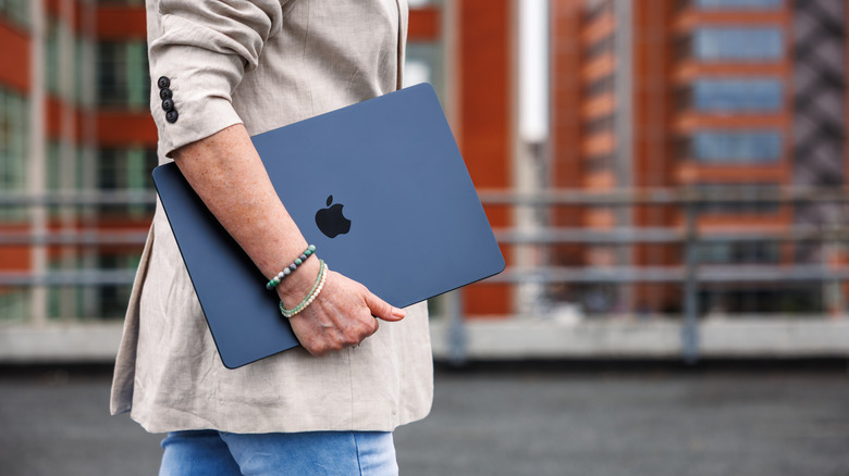 A person carrying a MacBook