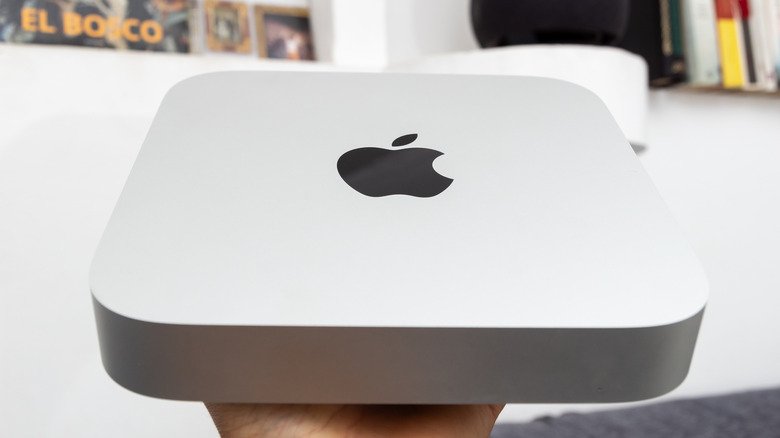 A person holding a Mac mini.