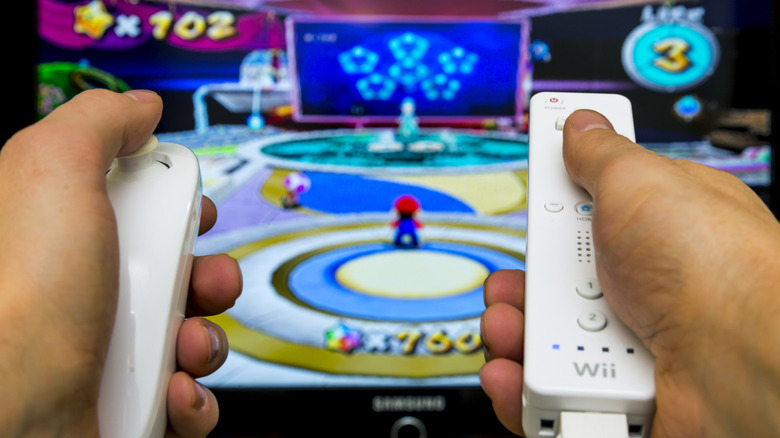 Close up of someone using the Nintendo Wii remotes to play a game.