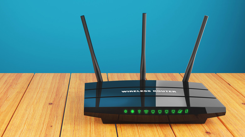 Green lights visible on the front of a wireless router resting atop a table.